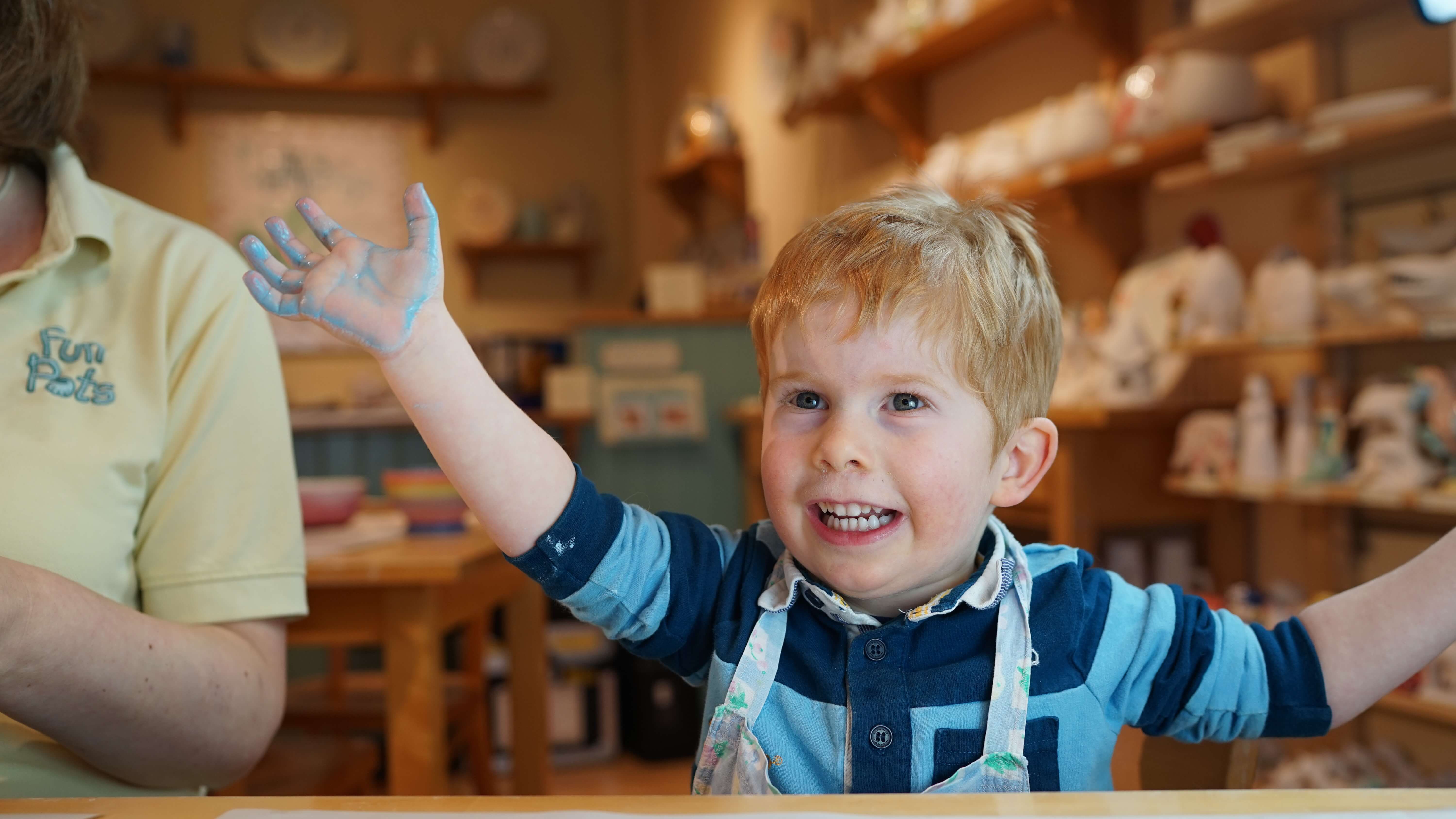 boy-happy-pottery-painting-in-studio